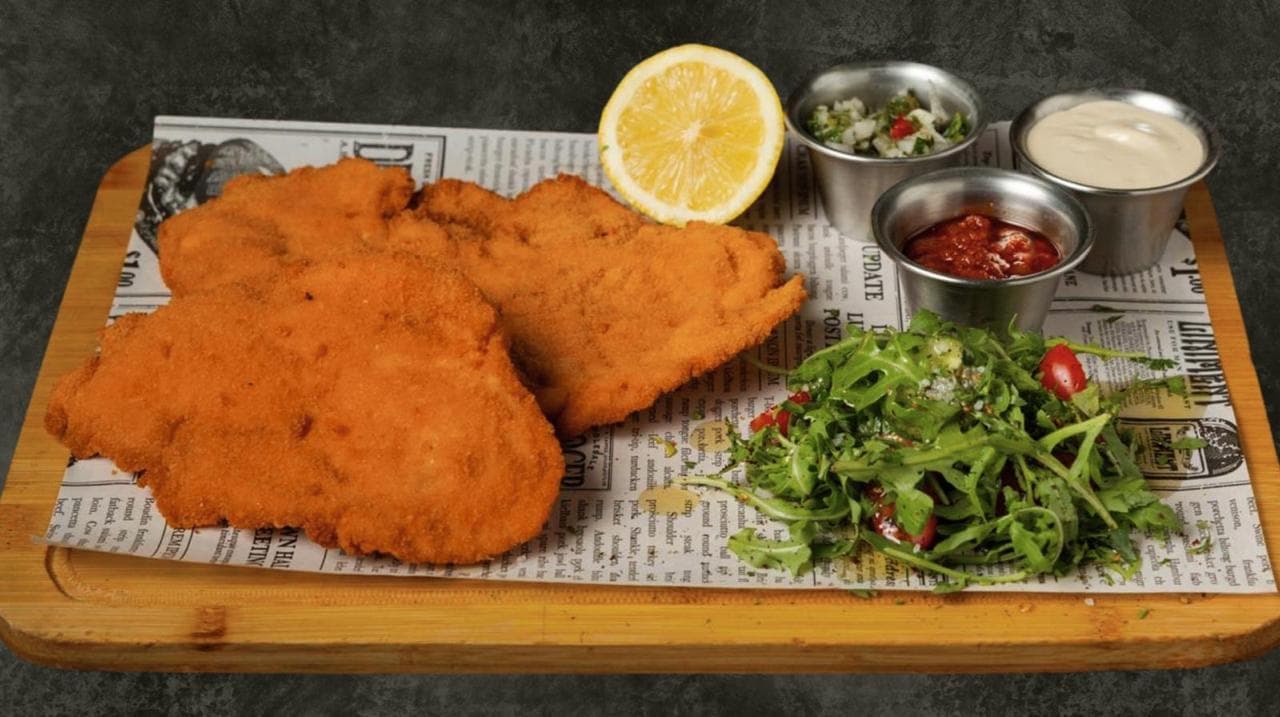Crispy golden schnitzel with salad and dips